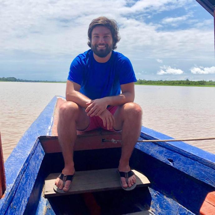 Foto de cliente sonriendo sobre un bote en el río