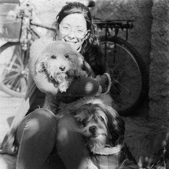 Foto de clienta sonriendo con dos perros
